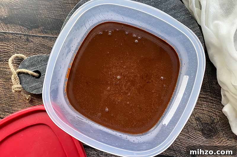 Horizontal image of a dark brown thick liquid in an airtight container.