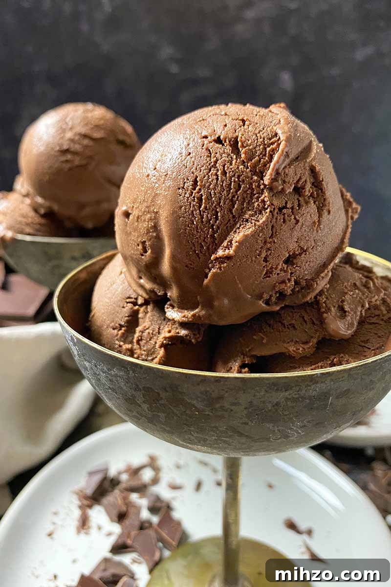 Vertical close-up image of metal goblets full of a dark brown frozen treat on a white plate.
