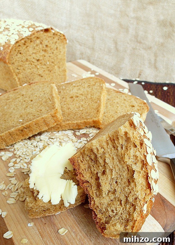 Old Neighborhood Oatmeal Porter Beer Bread Recipe 2 Sliced loaf of oatmeal beer bread. One slice has butter on it.