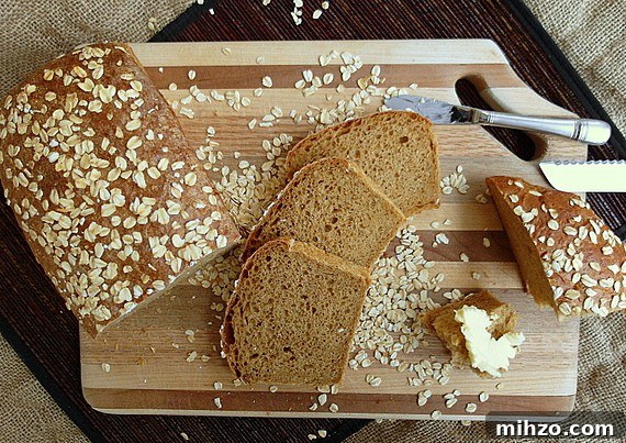 Old Neighborhood Oatmeal Porter Beer Bread Recipe 4 A whole loaf and slices of Oatmeal Porter Oatmeal Beer bread on a cutting board.
