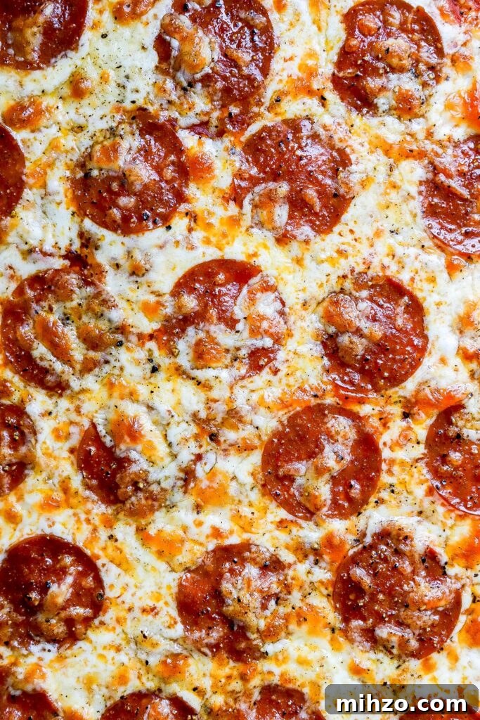 Top down view of protein chicken crust pizza with pepperoni and mozzarella cheese.