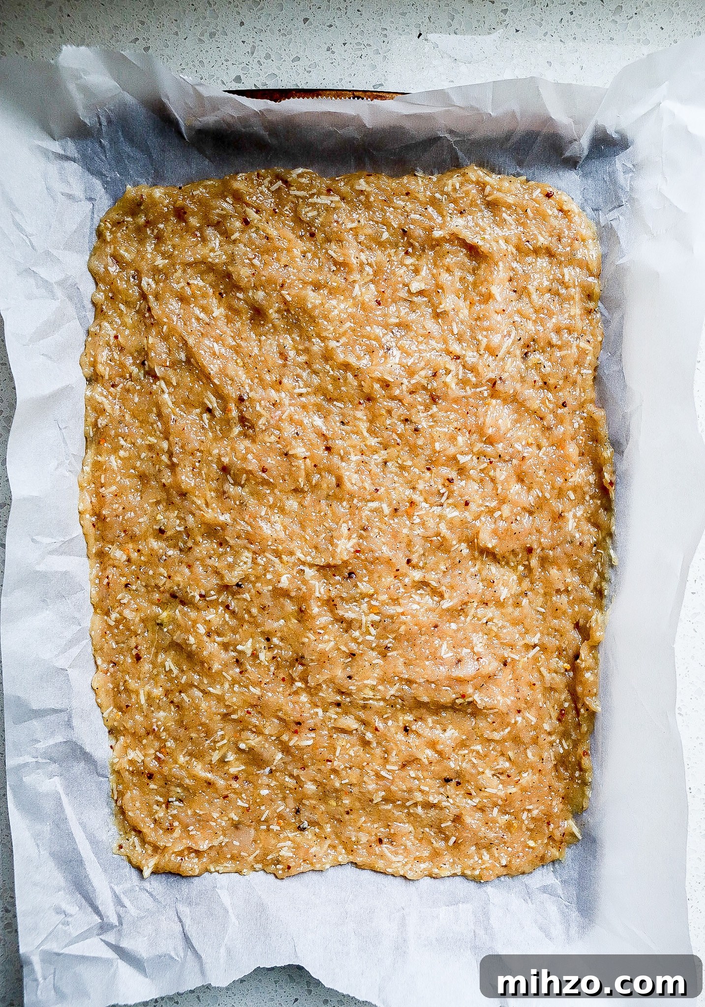 Top down view of raw chicken crust on baking sheet.