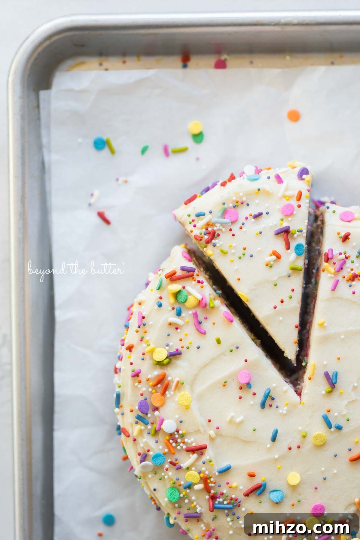 Single-Layer Funfetti Cake Recipe for Bright, Moist Celebration Cakes 12 Cut slice of single layer funfetti cake partially removed from rest of the cake on a parchment paper lined baking sheet | All images © Beyond the Butter®