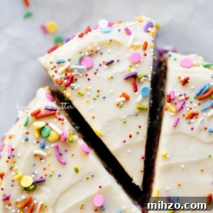 Single-Layer Funfetti Cake Recipe for Bright, Moist Celebration Cakes 18 Cut slice of single layer funfetti cake partially removed from rest of the cake on white parchment paper.