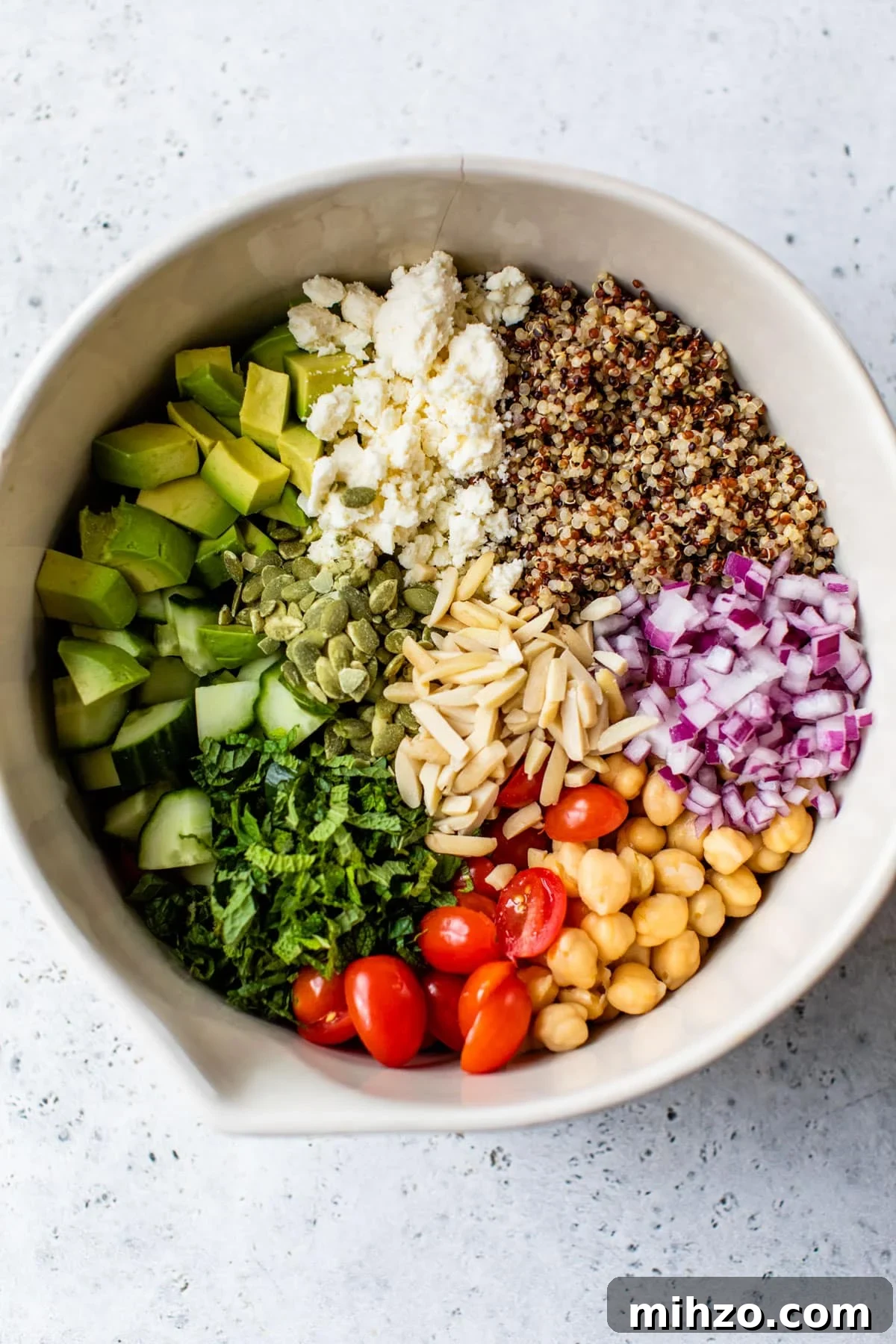 Zesty Lemon Quinoa Salad with Crispy Veggies and Herbs 3 bowl with quinoa, feta cheese, cucumber, and other vegetables inside
