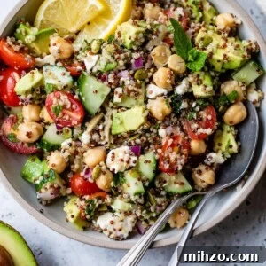 Zesty Lemon Quinoa Salad with Crispy Veggies and Herbs 6 bowl with quinoa, feta cheese, cucumber, and other vegetables inside and with a spoon