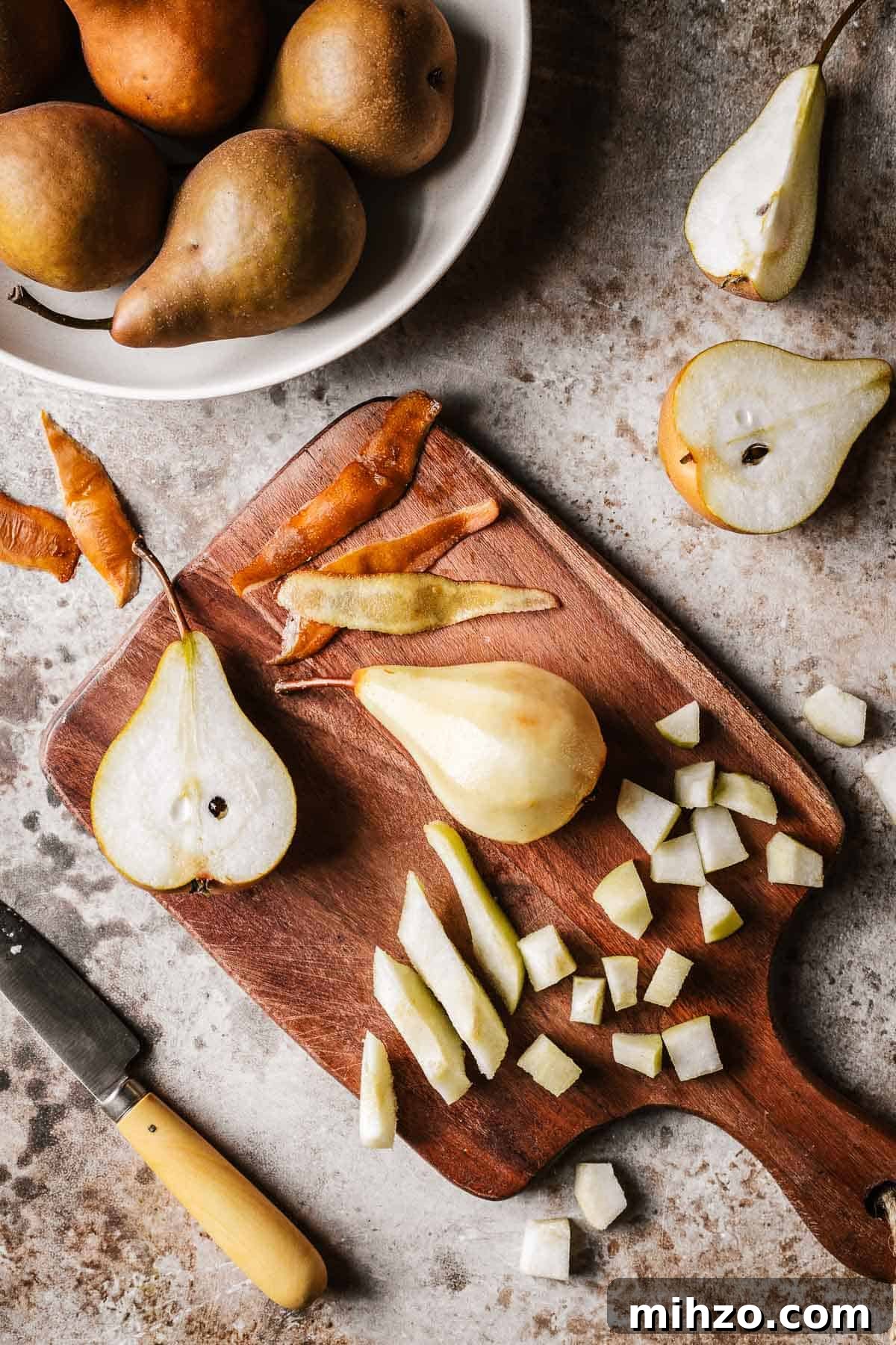Pears being diced on a wooden cutting board.