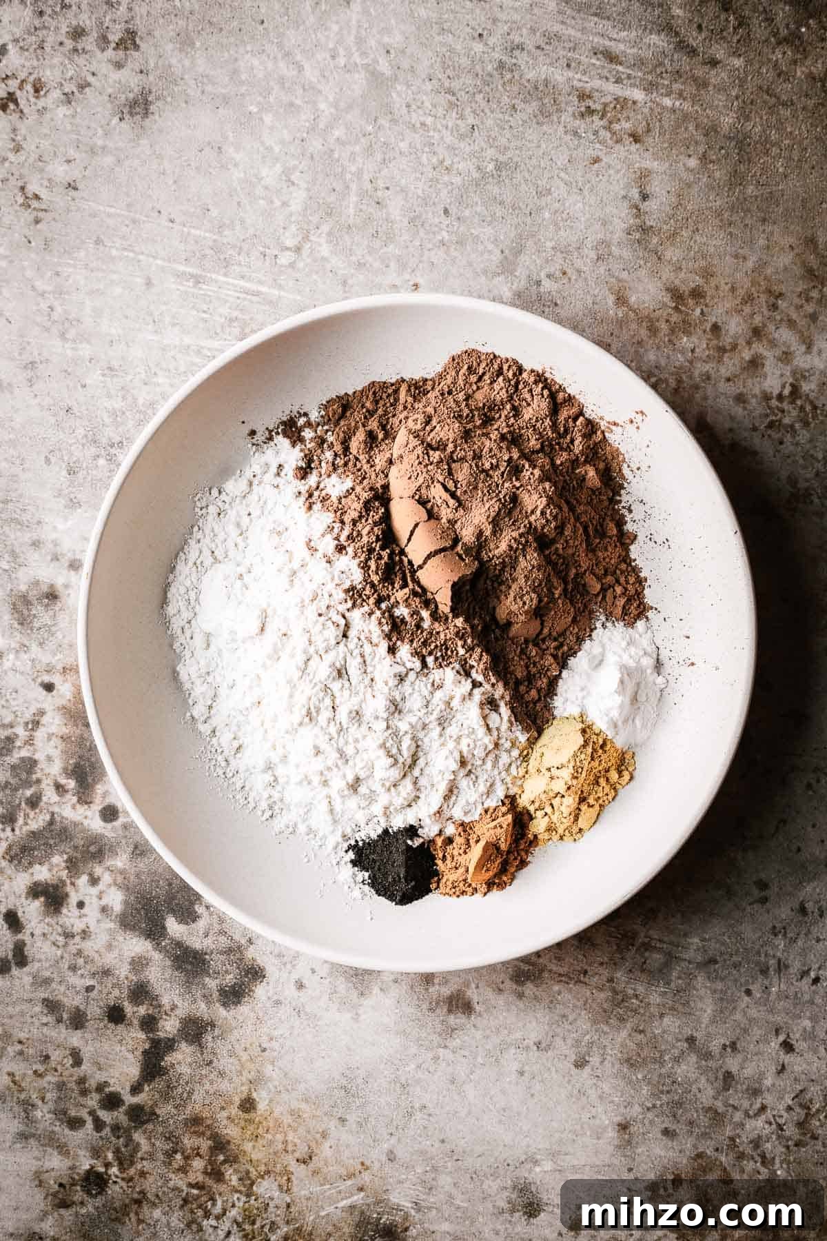 Flour, cocoa powder and ground spices in a shallow bowl.