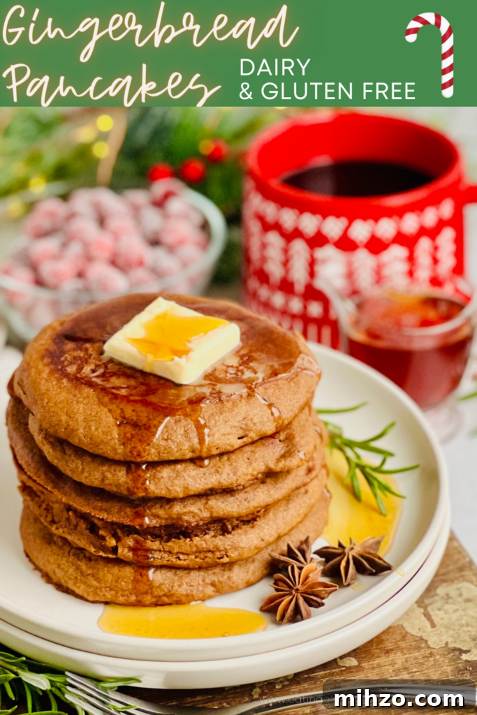 Gingerbread Pancakes Recipe: Fluffy Spiced Holiday Pancakes 2 A white plate filled with dark brown colored round pancakes with a large square of melty butter and syrup running down the top with a bright red mug of coffee in the background.