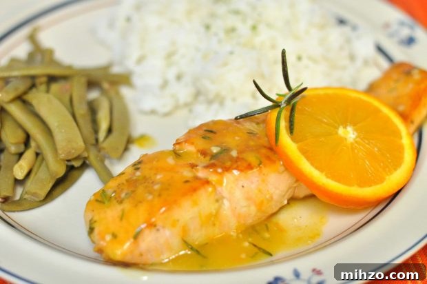 Orange rosemary glazed salmon, green beans and rice on a beige plate.