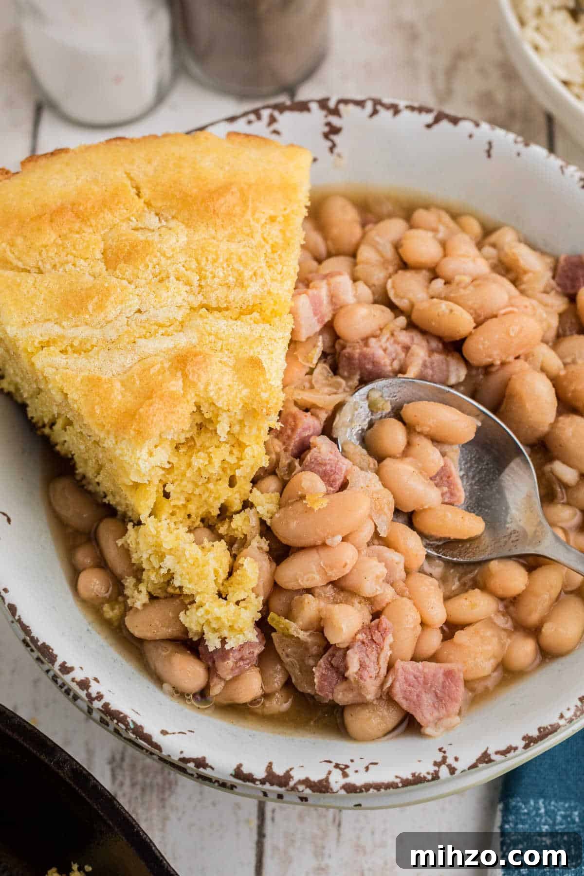 Southern-Style Great Northern Beans Recipe: Savory Slow-Cooker Method 2 Close up of a bowl full of southern great northern beans with a slice of cornbread on the side.