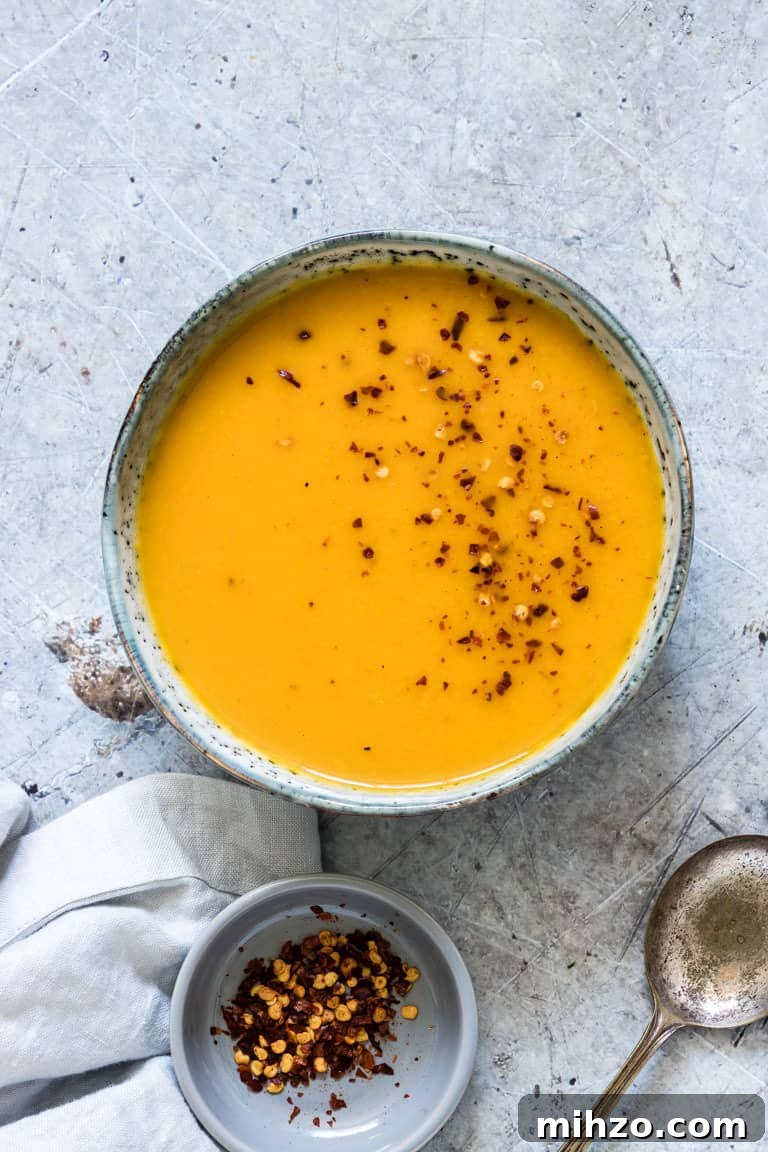 Creamy Kabocha Squash Soup Recipe for Fall Comfort 2 a bowl of kabocha squash soup on a table with a spoon