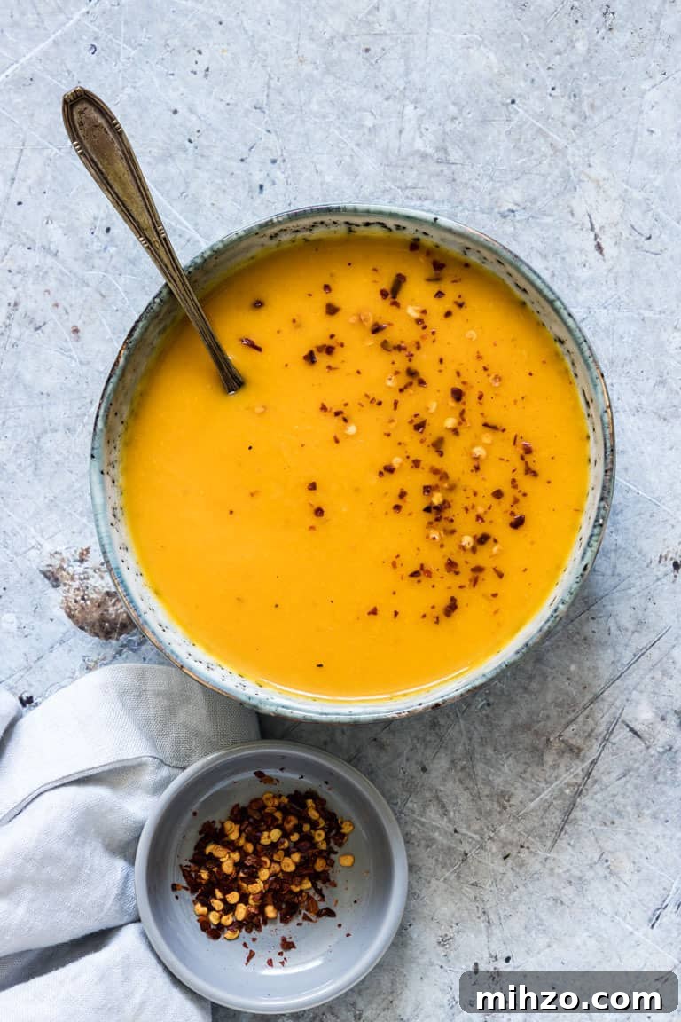 Creamy Kabocha Squash Soup Recipe for Fall Comfort 3 bowl of peanut butter and kabocha squash soup on a table with a spoon in it