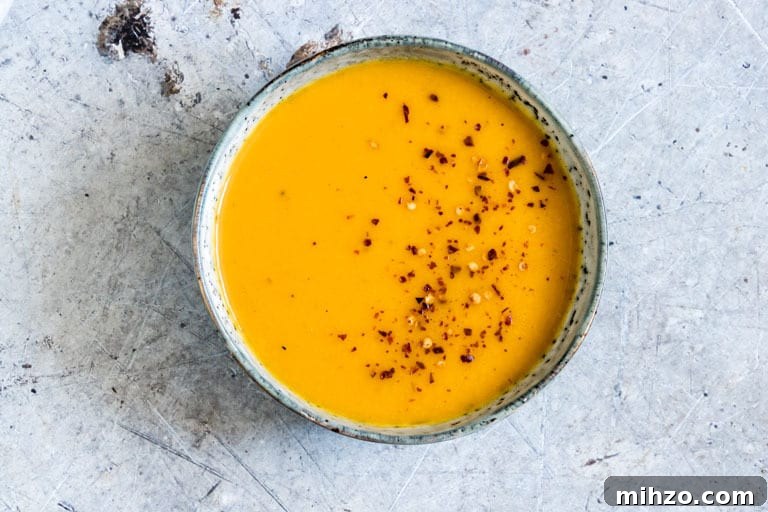 Creamy Kabocha Squash Soup Recipe for Fall Comfort 4 a bowl of Vegan Squash Soup With chili flakes