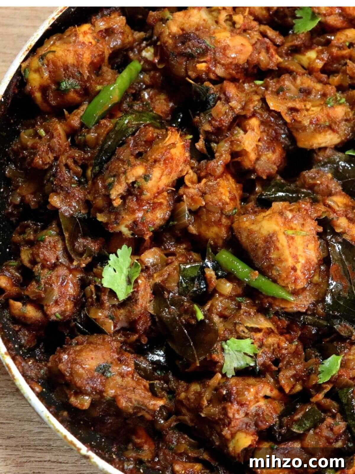 Andhra-Style Crispy Chicken Fry (Kodi Vepudu) 2 spicy Andhra chicken fry in a black pan.