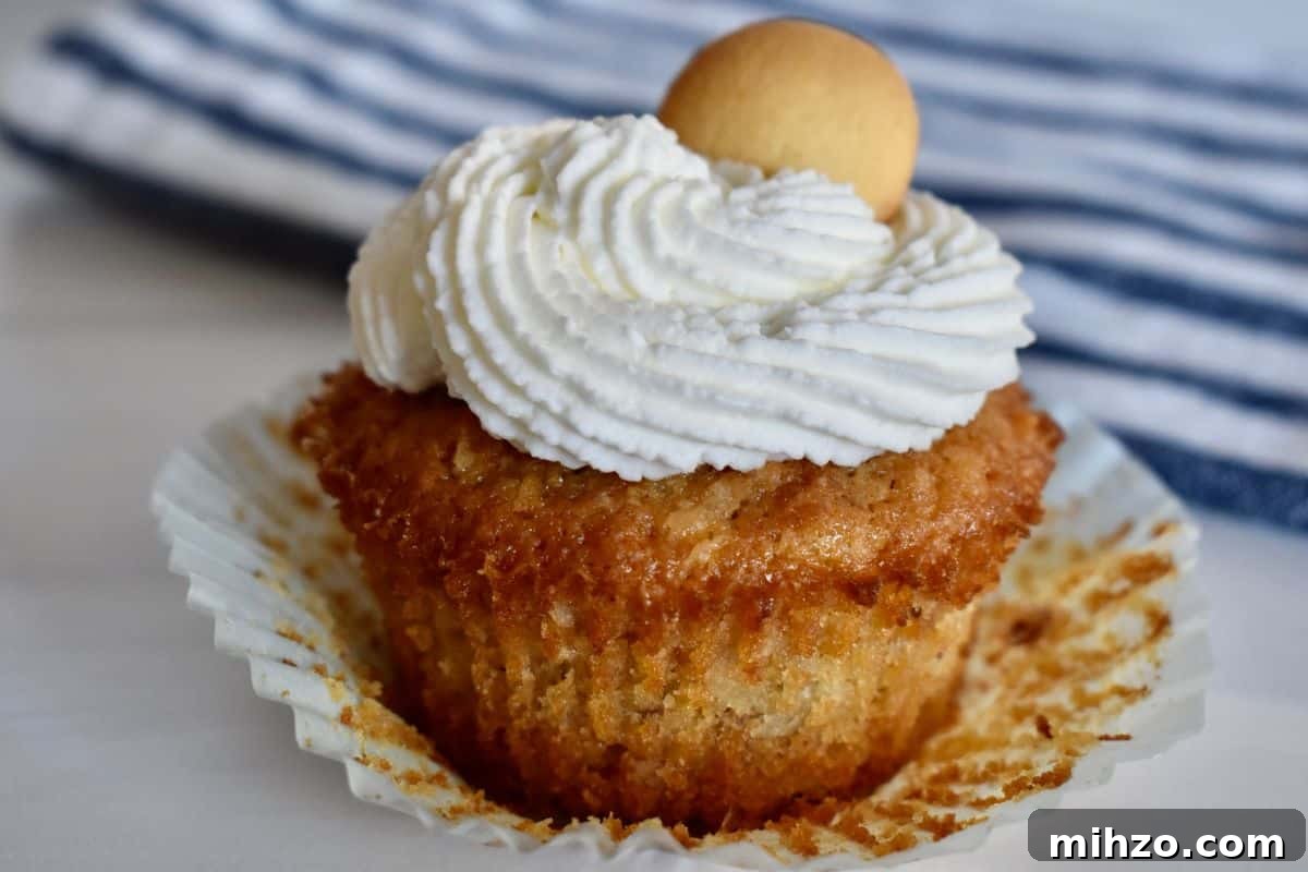 Classic Vanilla Wafer Cupcakes with Creamy Buttercream Frosting 3 Vanilla wafer cupcake with whipped cream frosting on a counter with a striped cloth in the background.