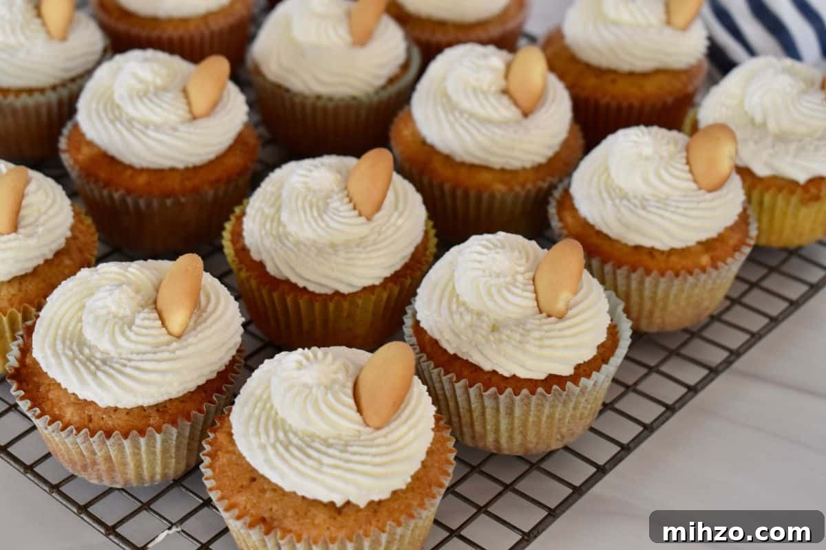 Classic Vanilla Wafer Cupcakes with Creamy Buttercream Frosting 7 Vanilla Wafer Cupcakes with whipped cream frosting on a wire rack with a Nilla wafer on top.
