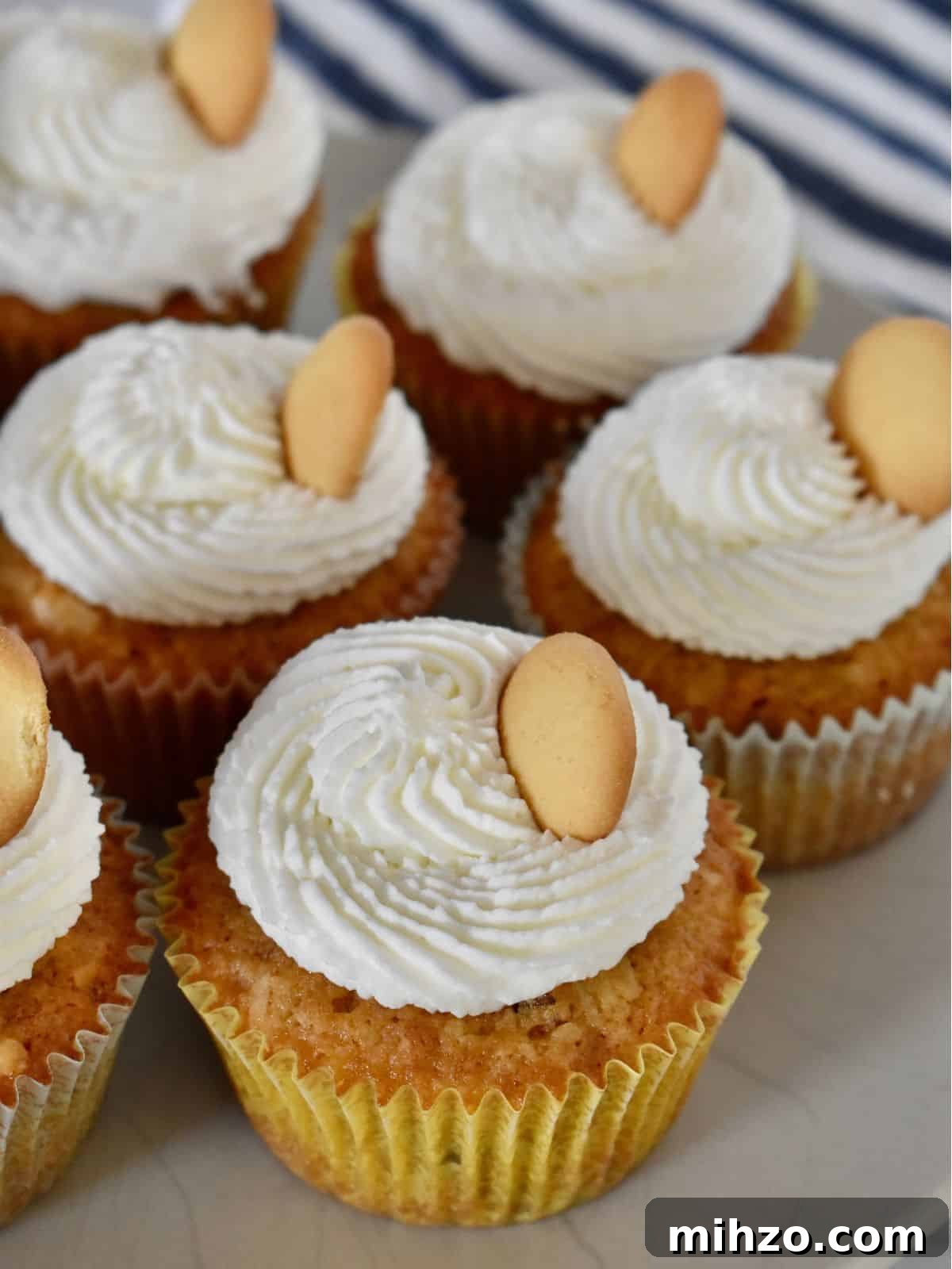 Classic Vanilla Wafer Cupcakes with Creamy Buttercream Frosting 8 finished recipe on a white plate with a striped napkin in the background.