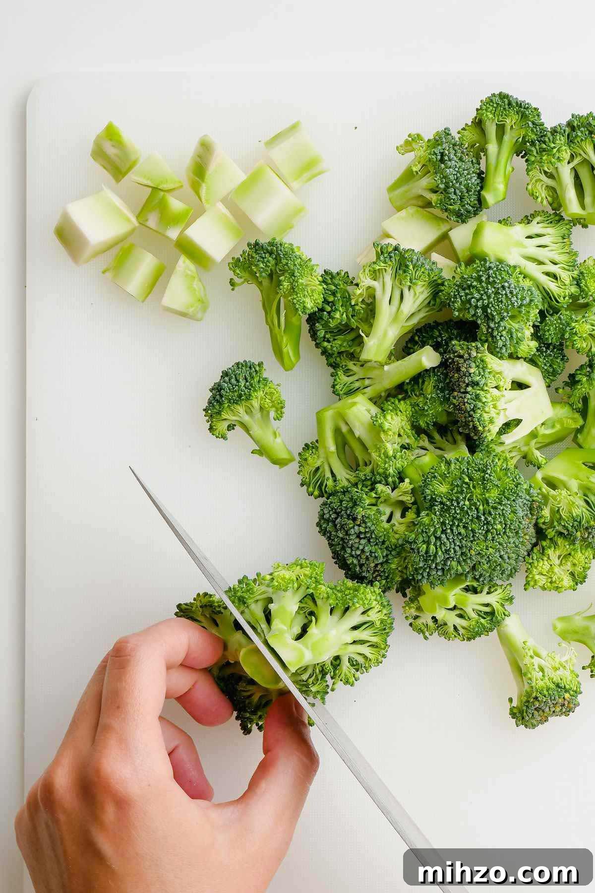 Blanch Broccoli Quickly: Perfectly Crisp, Bright Green Every Time 4 a broccoli floret being cut on white cutting board