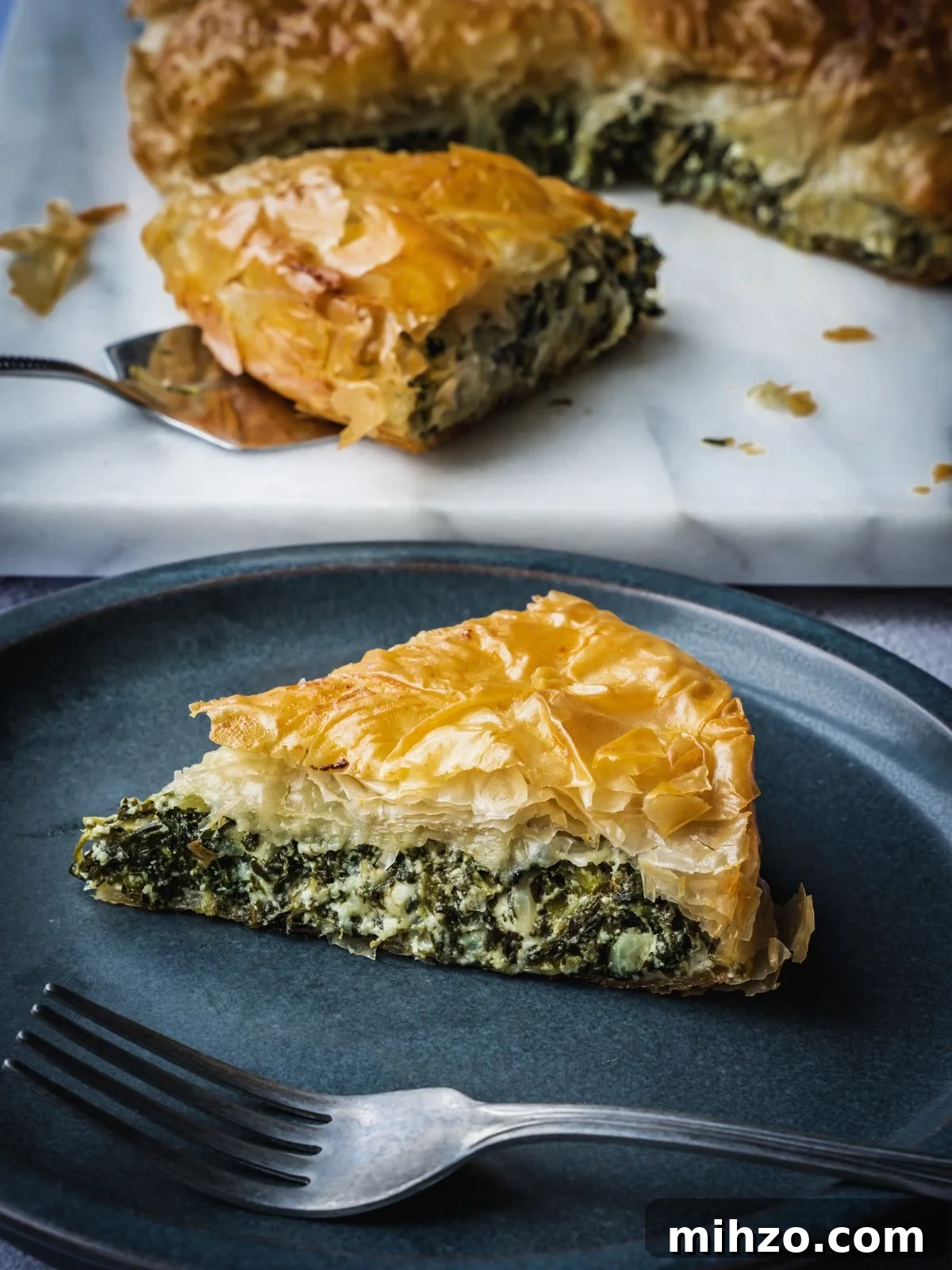 Authentic Spanakopita: Classic Greek Spinach Pie with Phyllo 2 Greek spinach pie slice on a plate.