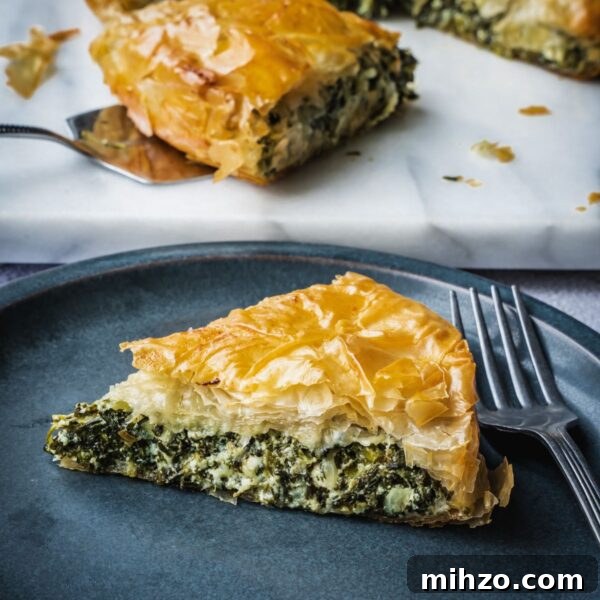 Authentic Spanakopita: Classic Greek Spinach Pie with Phyllo 13 Greek spinach pie slice on a plate.