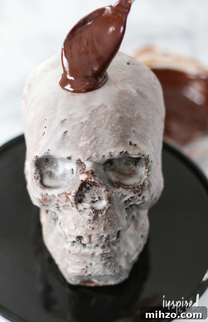 Chocolate Skull Cake Recipe: Decadent Layered Halloween Dessert 10 spoon adding a chocolate drip to a Skull Cake.