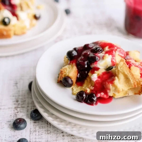 A slice of Overnight Blueberry French Toast on a plate with fresh blueberries.