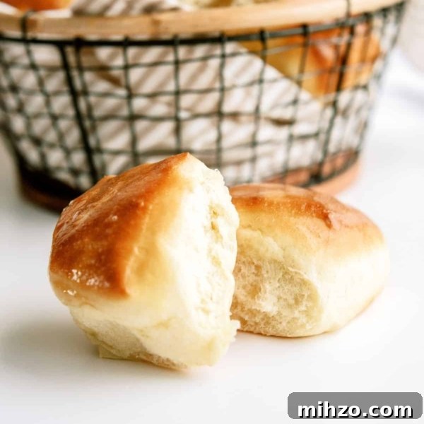2 Texas Roadhouse Rolls in front of a basket filled with Texas Roadhouse Rolls.
