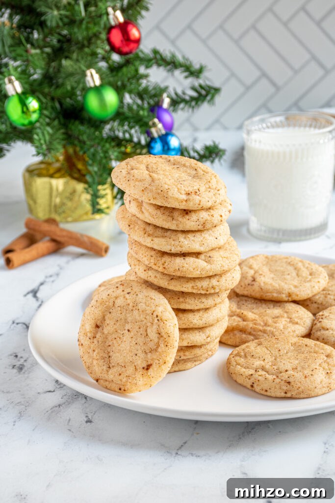 Eggnog Snickerdoodle Cookies with Warm Spices and Creamy Rum Option 11 A tall stack of eggnog snickerdoodles on a plate with a cookie leaning against the stack.