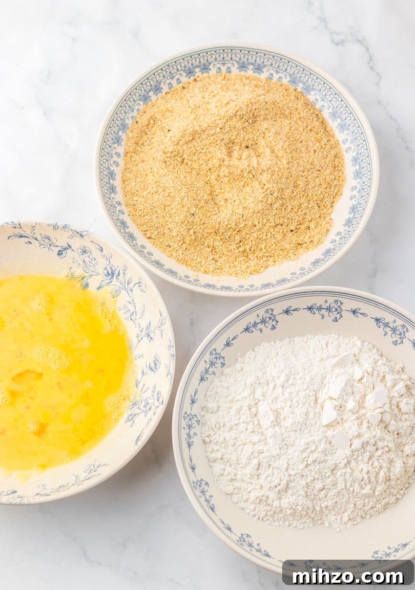 breading ingredients in three shallow white bowls