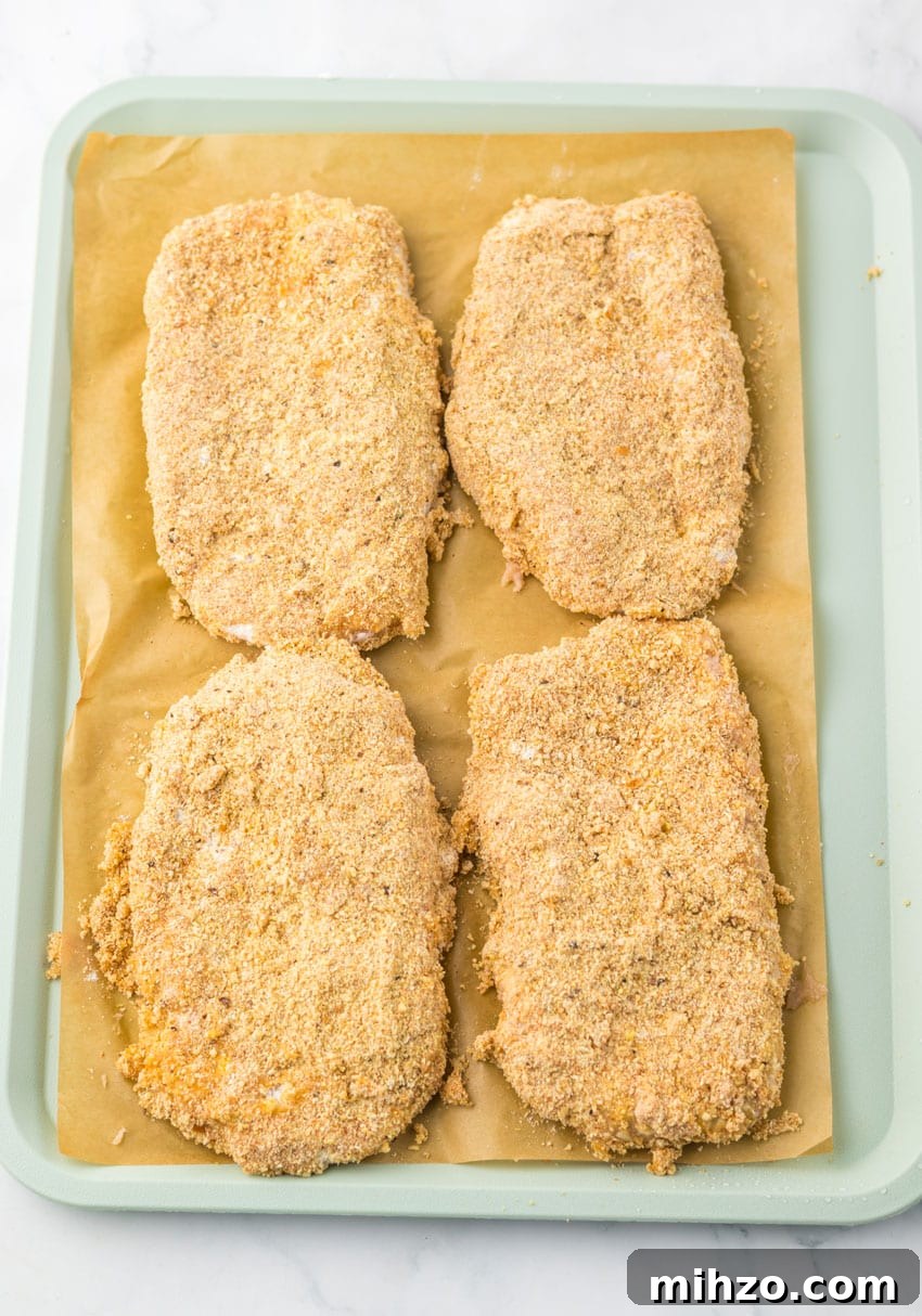 four homemade breaded chicken patties on a sheet of brown parchment paper