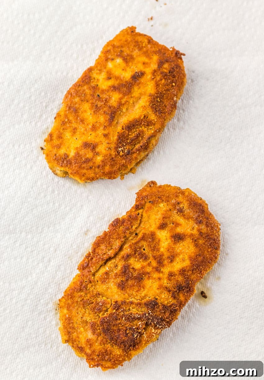 two fried chicken patties on white paper towels