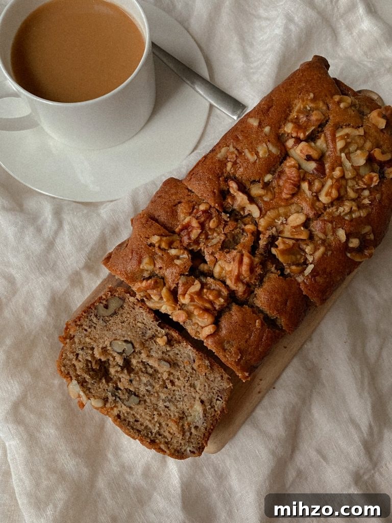 Gluten-Free Banana Bread Recipe That Actually Tastes Great 4 walnut banana bread sliced on a wood board with white mug of coffee