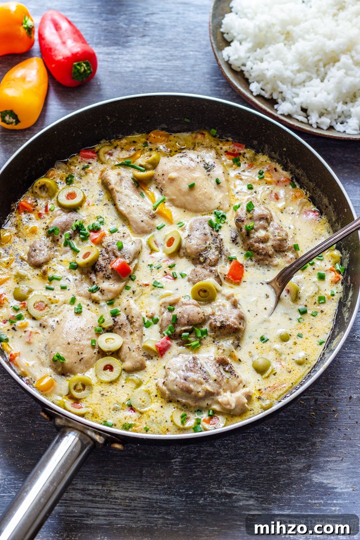 Creamy Garlic Boneless Skinless Chicken Thighs Recipe 6 Creamy chicken thighs with olives and peppers in a skillet, with rice on the side.