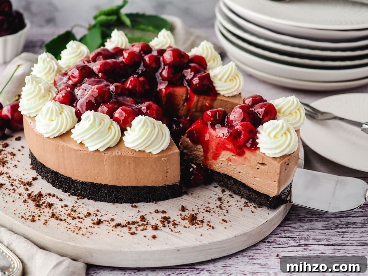 Taking a slice out of a black forest cheesecake, with a stack of plates in the background.