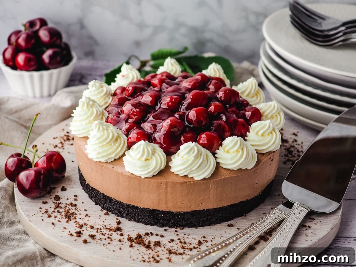 A whole black forest cherry cheesecake on a serving board with serving wear.