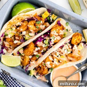 Shrimp tacos stuffed and stacked in a gray baking pan