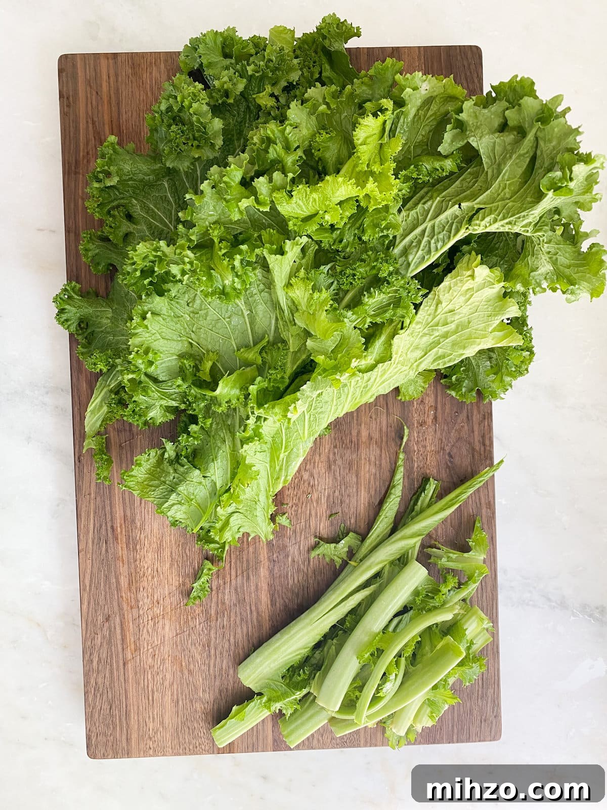 Preparing the escarole by cutting off steams.
