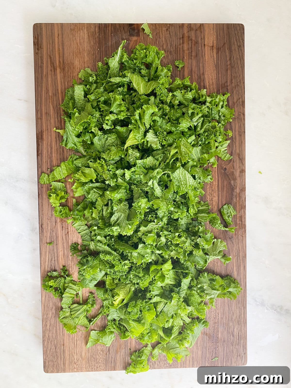 Escarole chopped on a wooden cutting board. 