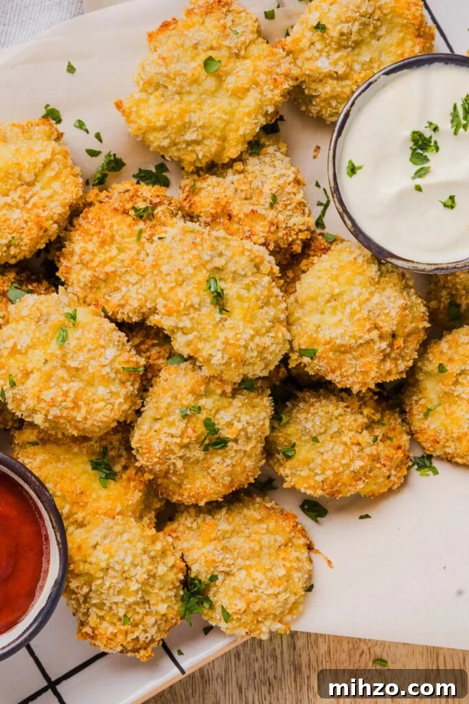 Cauliflower chicken nuggets with two dipping sauces on parchment paper.