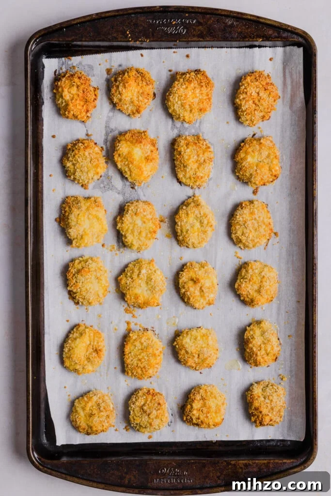 Cauliflower chicken nuggets baked on a baking sheet.
