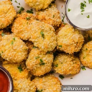 Cauliflower chicken nuggets with two dipping sauces on parchment paper.
