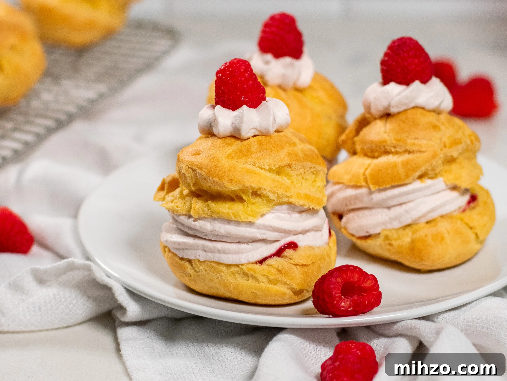 A choux pastry bun filled with raspberry cream cheese whipped cream and raspberry jam.