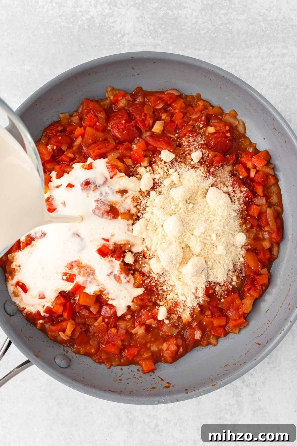 Creamy Kielbasa and Smoked Sausage Pasta Skillet Recipe 7 Heavy cream and parmesan are added to the tomato sauce in the large skillet.