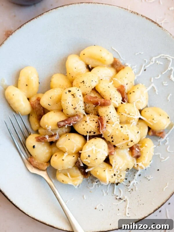 An overhead shot of a plate of gnocchi with carbonara sauce