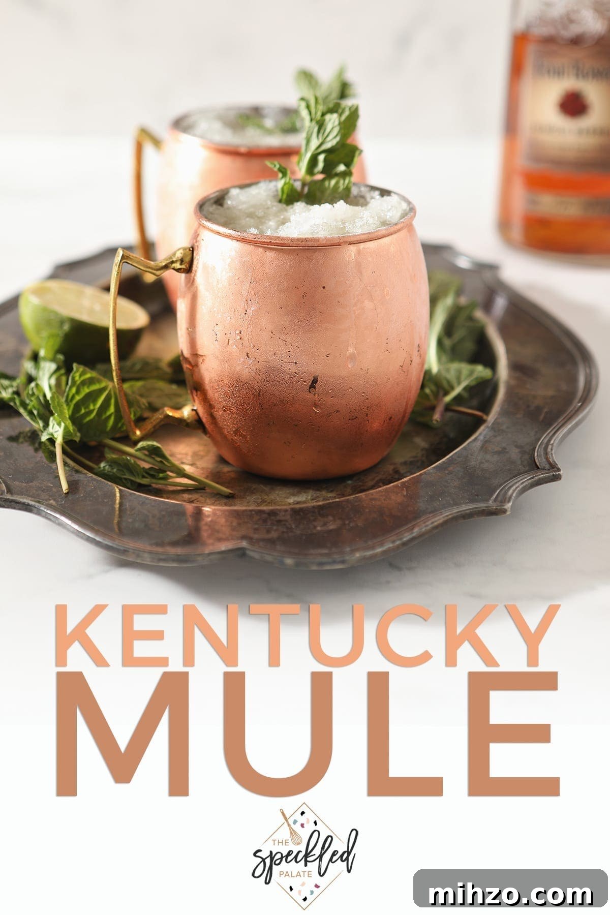 A silver platter holds two copper mugs holding Kentucky Bourbon Mules, with Pinterest text