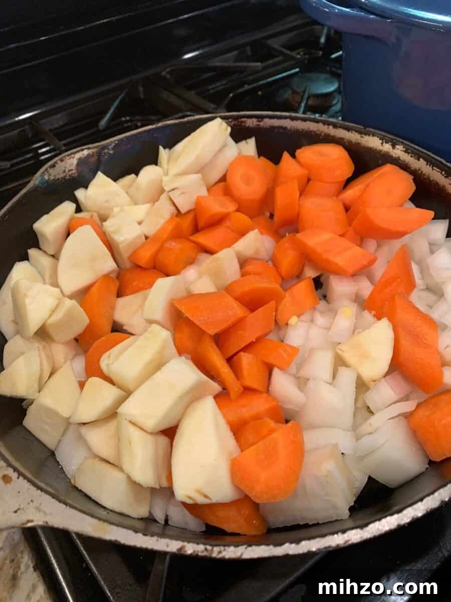 Classic Irish Beef Stew Recipe for Tender, Rich Flavor 7 Parsnips, carrots and onion in a skillet.
