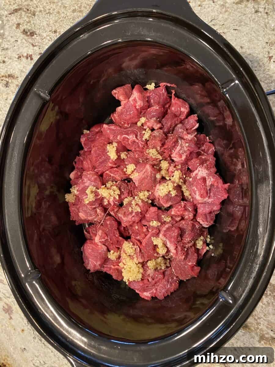 Classic Irish Beef Stew Recipe for Tender, Rich Flavor 10 Beef and garlic in a crockpot.