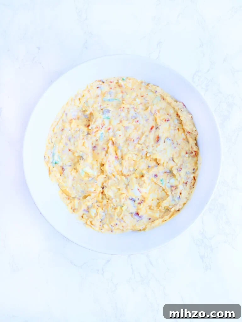 Smoky Chipotle Pimento Cheese Spread with a Spicy Kick 5 Mixed pimento cheese ingredients in a white mixing bowl.
