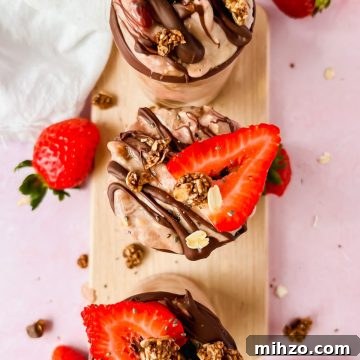 Chocolate-Strawberry Overnight Oats Recipe for Creamy Mornings 9 three glasses filled with brownie batter overnight oats and topped with fresh strawberries.